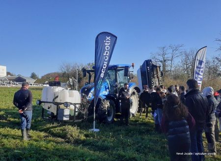 Publics de jeunes devant un tracteur et son matériel agricole de traitement dans une paririe